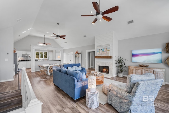 living room featuring a fireplace, wood-type flooring, and lofted ceiling