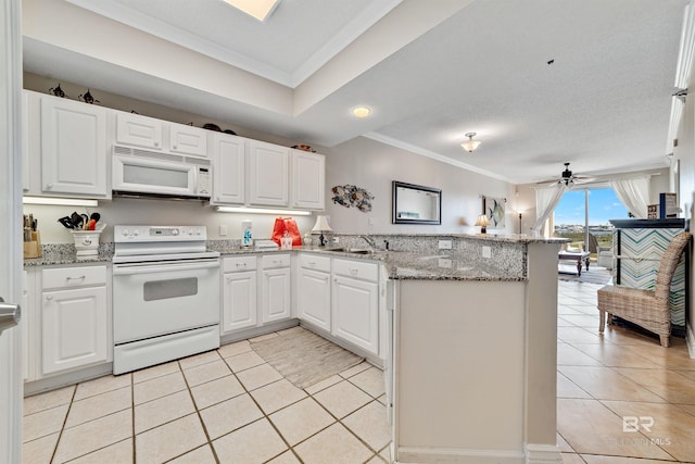 kitchen with white appliances, crown molding, light tile patterned flooring, and a peninsula