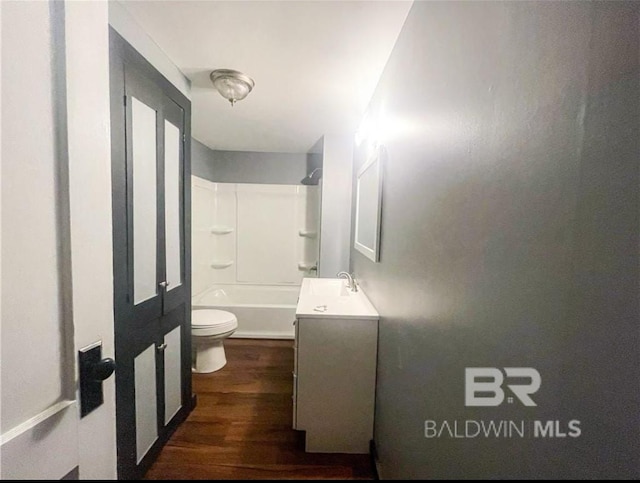 full bathroom with hardwood / wood-style floors, vanity, shower / bathtub combination, and toilet