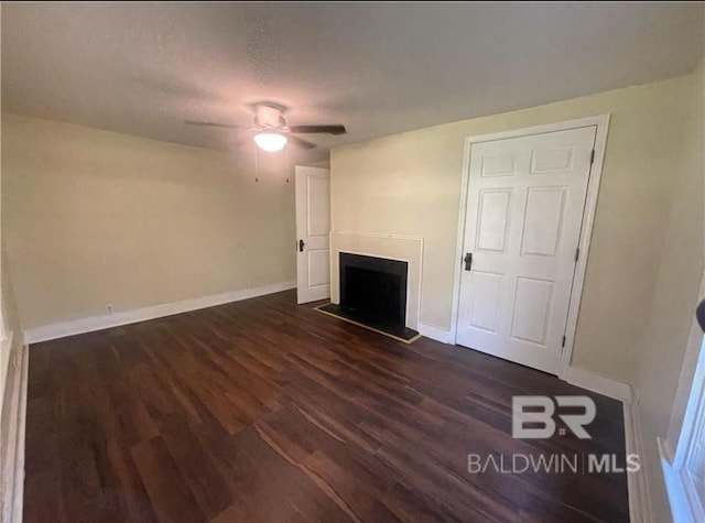 unfurnished living room with ceiling fan, dark hardwood / wood-style flooring, and a textured ceiling