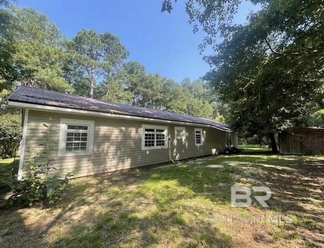 rear view of house featuring a lawn