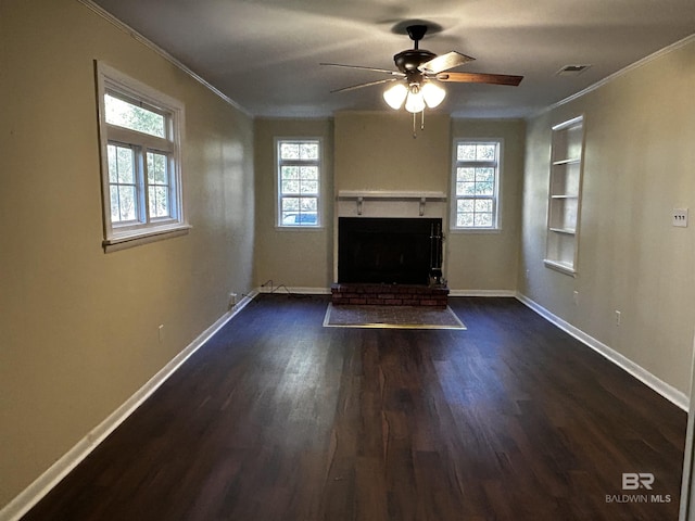 unfurnished living room with a brick fireplace, ceiling fan, built in shelves, ornamental molding, and dark hardwood / wood-style flooring