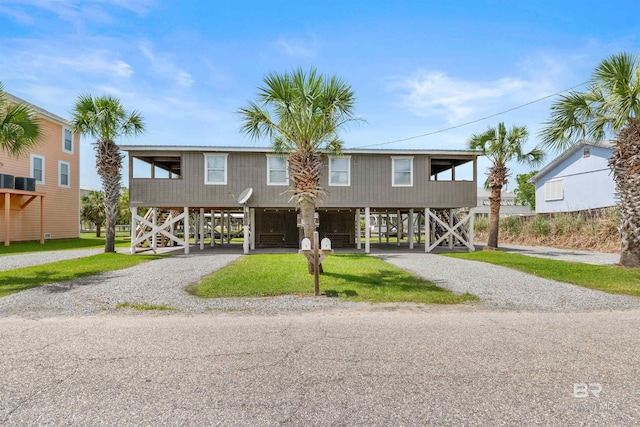 120 W 3rd Ave, Gulf Shores, AL 36542 - beach home with a carport, gravel driveway, stairway, and a front lawn