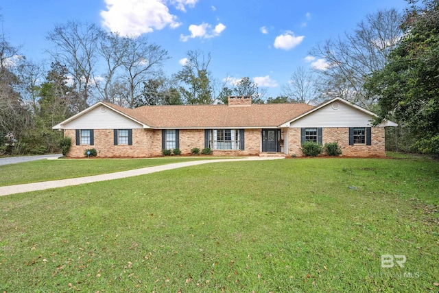 ranch-style home featuring a front yard, brick siding, and a chimney