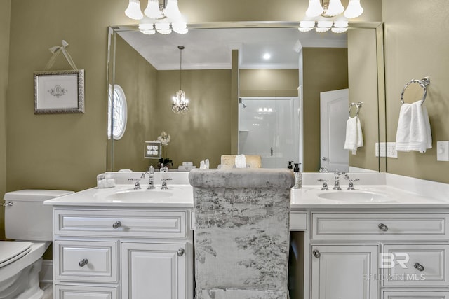 bathroom with an inviting chandelier, double sink vanity, toilet, and ornamental molding