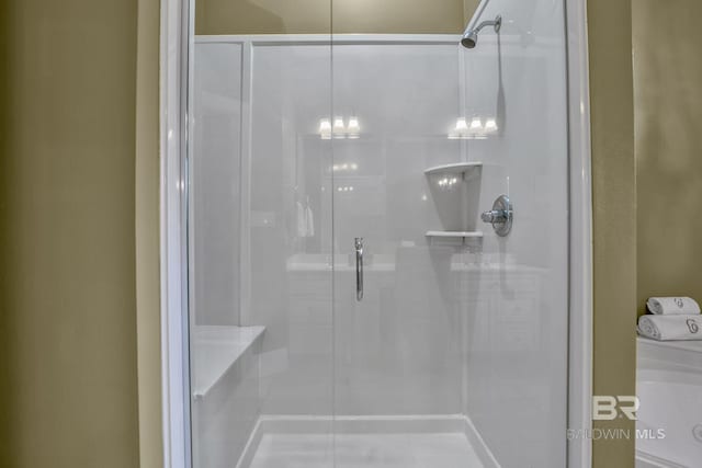 bathroom with a shower with door and tile floors