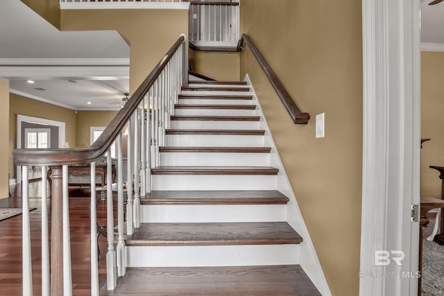 stairway featuring crown molding, wood-type flooring, and ceiling fan