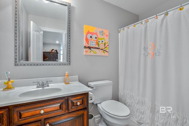 bathroom with toilet and vanity with extensive cabinet space