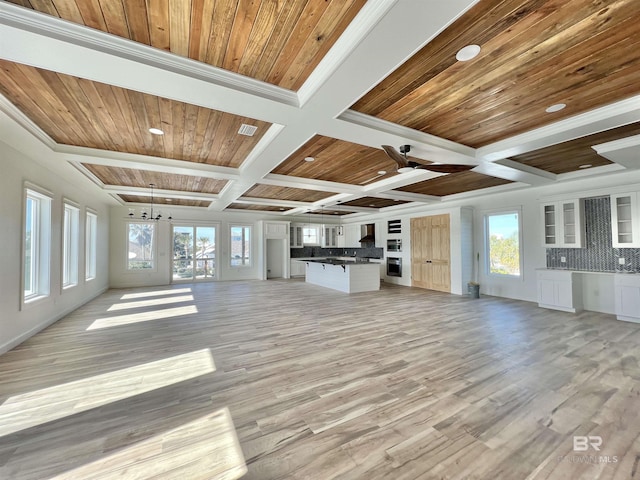 unfurnished living room featuring visible vents, a wealth of natural light, light wood finished floors, and coffered ceiling