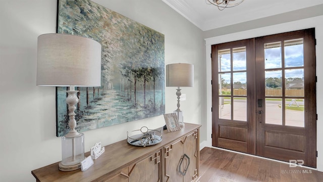 foyer with crown molding, french doors, and wood finished floors