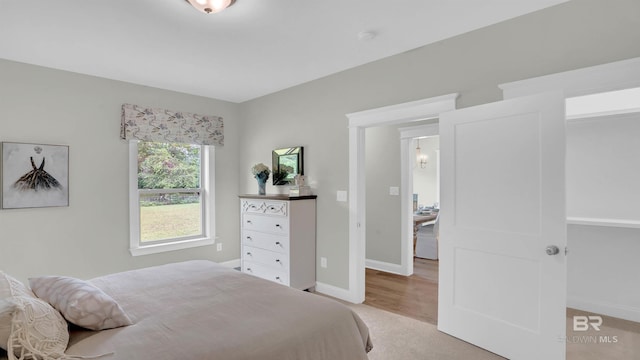 bedroom featuring baseboards and light colored carpet