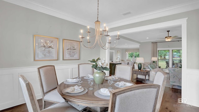 dining space with visible vents, a decorative wall, ornamental molding, wood finished floors, and a wainscoted wall