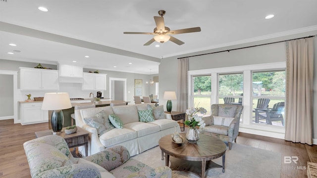 living area with recessed lighting, ceiling fan, ornamental molding, and wood finished floors