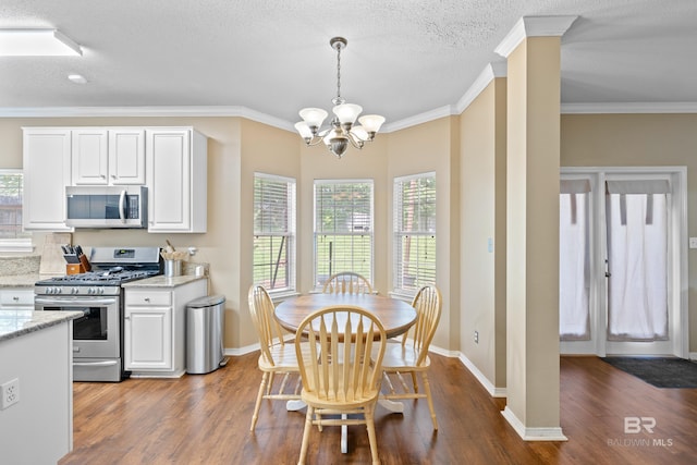 dining space with ornamental molding, dark hardwood / wood-style flooring, an inviting chandelier, and a textured ceiling