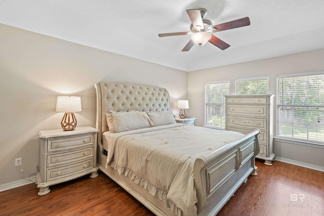 bedroom with ceiling fan, dark wood-type flooring, and a textured ceiling