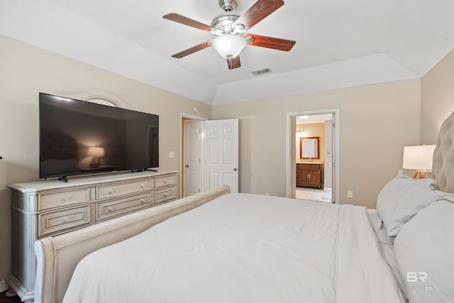 bedroom featuring lofted ceiling, ensuite bathroom, a raised ceiling, and ceiling fan