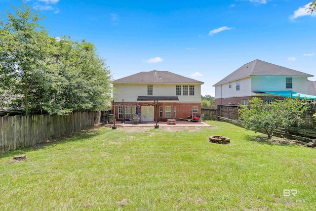 rear view of house with a lawn, an outdoor fire pit, and a patio area