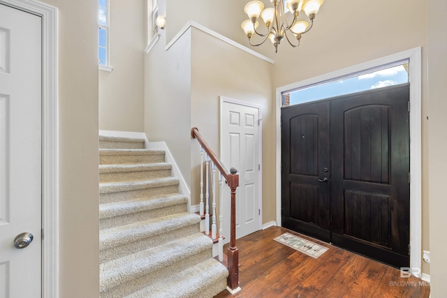 foyer entrance with a chandelier and dark hardwood / wood-style floors