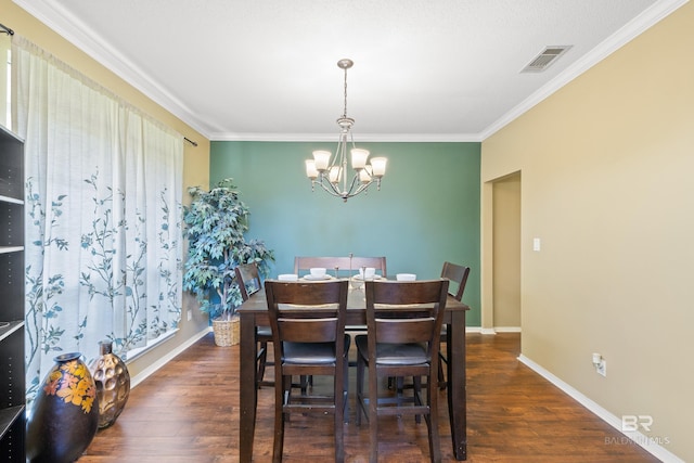 dining room with dark hardwood / wood-style flooring, crown molding, and a notable chandelier