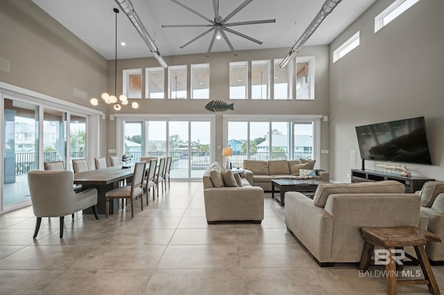 living room featuring a notable chandelier, a healthy amount of sunlight, and a high ceiling