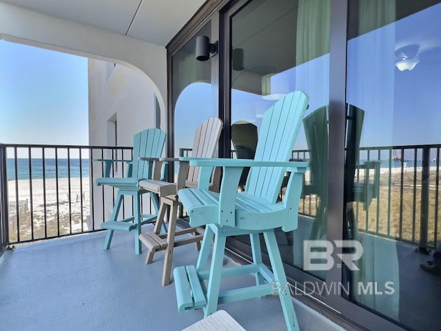 balcony featuring a water view and a view of the beach