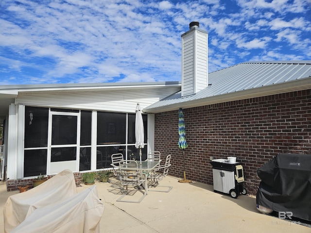 view of patio / terrace with area for grilling and a sunroom