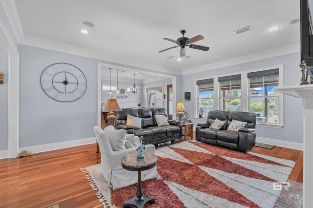 living area with baseboards, visible vents, wood finished floors, and ceiling fan with notable chandelier