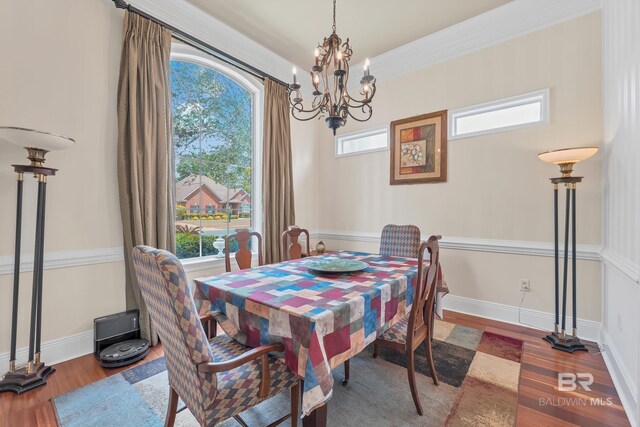 dining room featuring baseboards, wood finished floors, and a notable chandelier