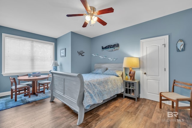 bedroom featuring baseboards, ceiling fan, and wood finished floors
