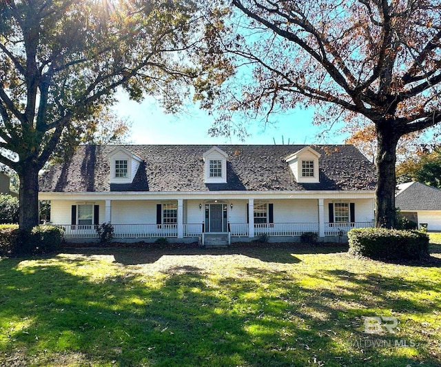 cape cod house featuring a front yard