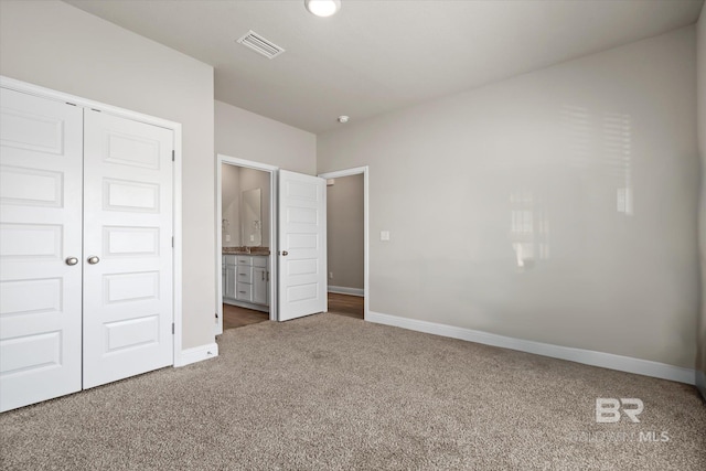 unfurnished bedroom featuring connected bathroom, carpet flooring, and a closet