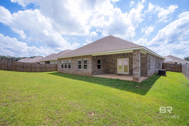 rear view of property with a yard, a patio, and central air condition unit