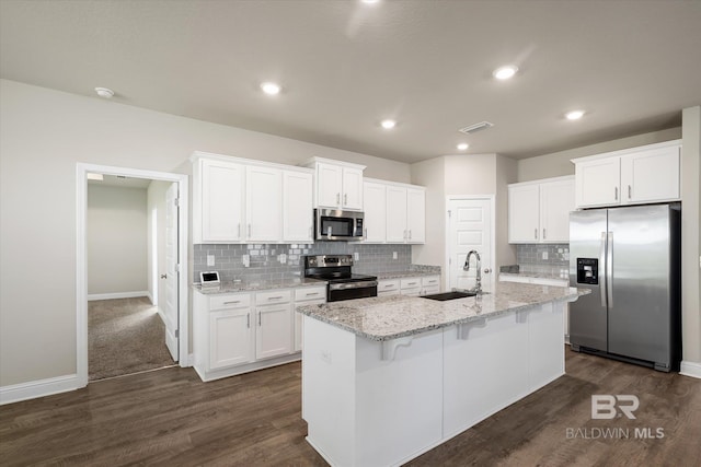 kitchen featuring an island with sink, stainless steel appliances, white cabinets, and sink