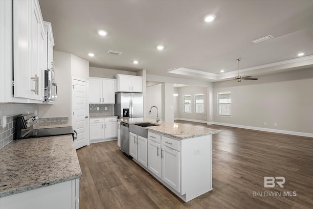 kitchen with appliances with stainless steel finishes, a center island with sink, white cabinetry, and ceiling fan