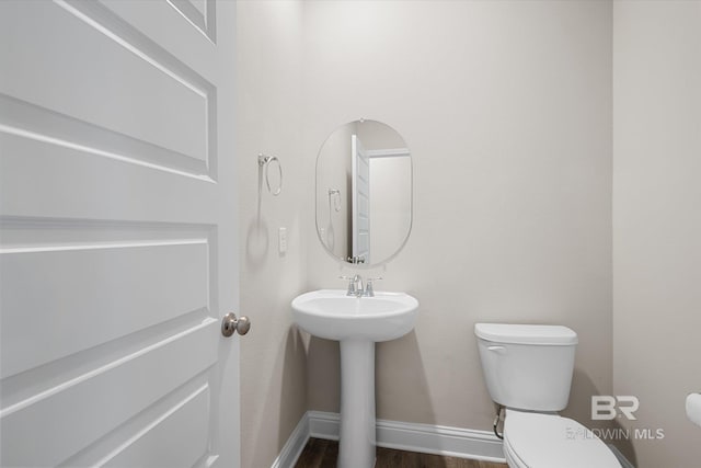 bathroom with wood-type flooring and toilet