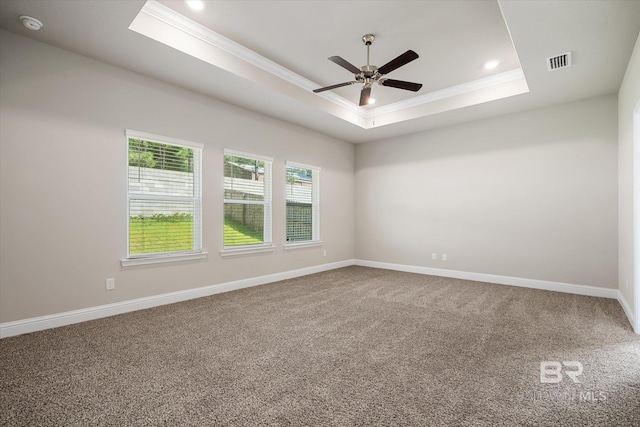 spare room with ceiling fan, a tray ceiling, crown molding, and carpet flooring