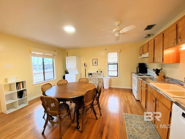106 Ryan Ct, Dauphin Island, AL 36528 - dining space with stacked washer and clothes dryer, healthy amount of natural light, light wood-type flooring, and a ceiling fan