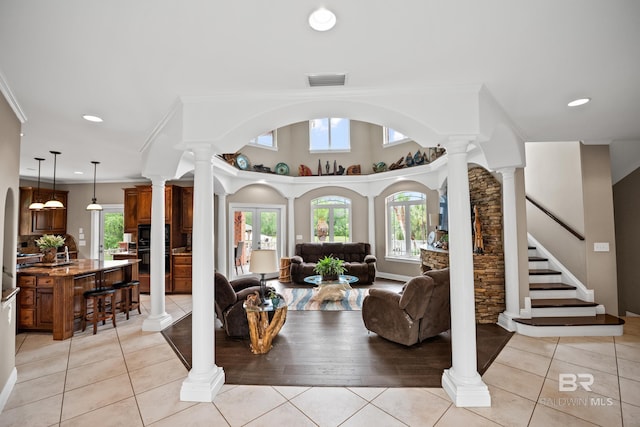 living room featuring decorative columns, plenty of natural light, light tile patterned floors, recessed lighting, and crown molding