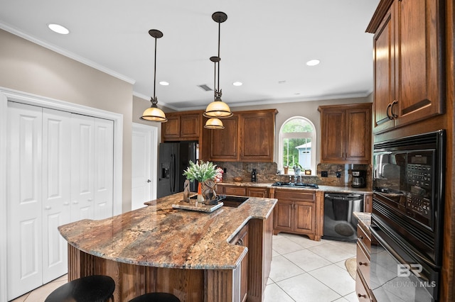 kitchen featuring black appliances, decorative backsplash, light tile patterned floors, a center island, and stone countertops