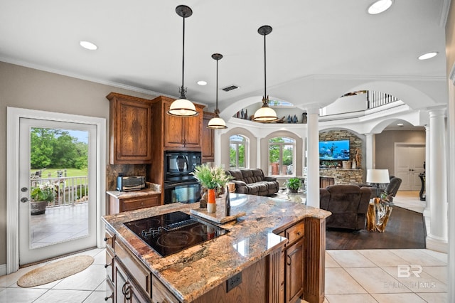 kitchen with decorative columns, black appliances, light tile patterned floors, open floor plan, and healthy amount of natural light