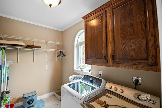 laundry area featuring cabinet space, washing machine and clothes dryer, ornamental molding, baseboards, and light tile patterned flooring