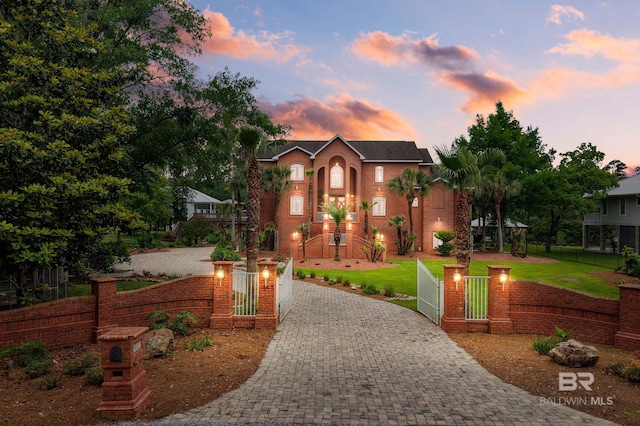 view of front of house with curved driveway and a gate