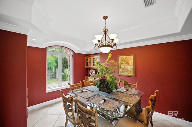 dining area with a tray ceiling, light tile patterned flooring, a chandelier, ornamental molding, and baseboards