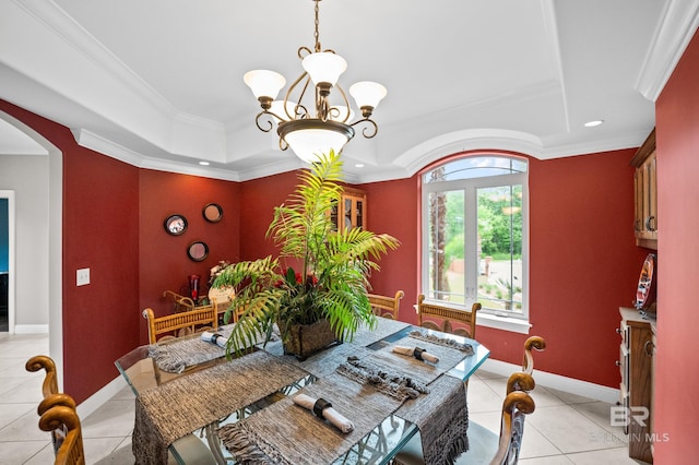 dining area with a chandelier, light tile patterned floors, a raised ceiling, arched walkways, and ornamental molding