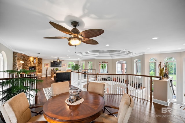 dining area featuring wood finished floors, a ceiling fan, recessed lighting, a fireplace, and ornamental molding