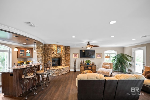 living room with dark wood-type flooring, a fireplace, crown molding, recessed lighting, and ceiling fan