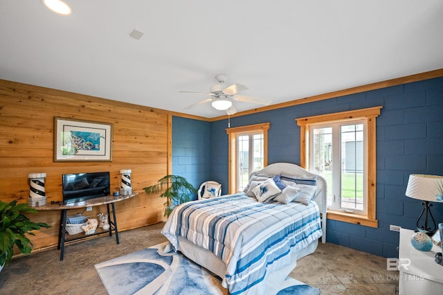 bedroom with wooden walls and ceiling fan