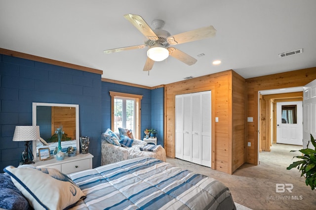 bedroom featuring a closet, ceiling fan, wood walls, and recessed lighting