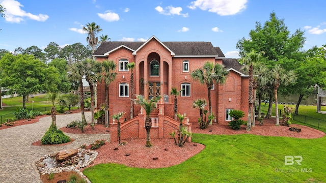 view of front of home featuring decorative driveway and brick siding