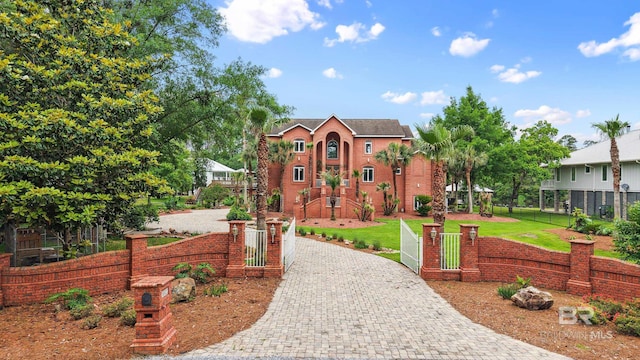 view of front of home with decorative driveway and a gate